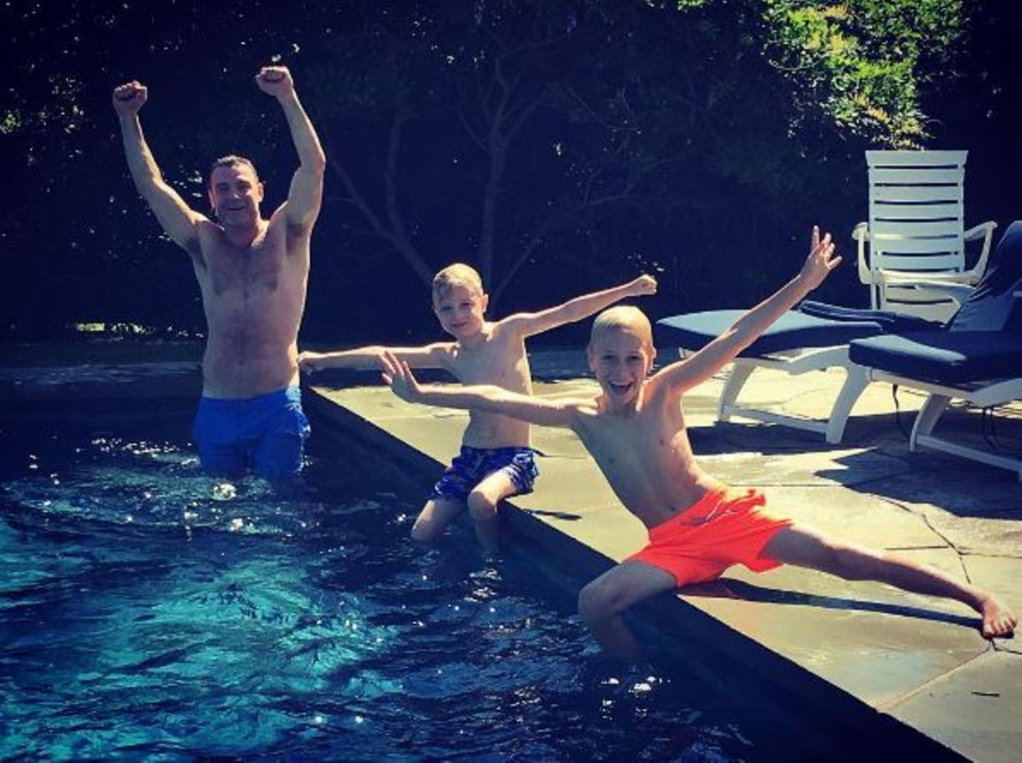 August 2016   Sommerzeit ist Badezeit: Liev Schreiber und seine beiden Söhne toben im Pool.