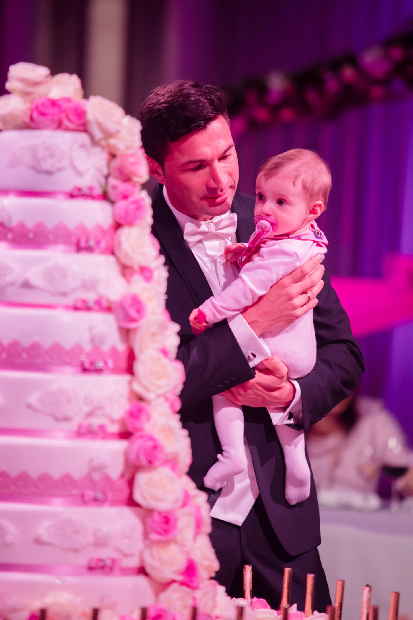 Gemeinsam mit ihrem Papa Lucas nimmt die kleine Sophia die achtstöckige Hochzeitstorte unter die Lupe.