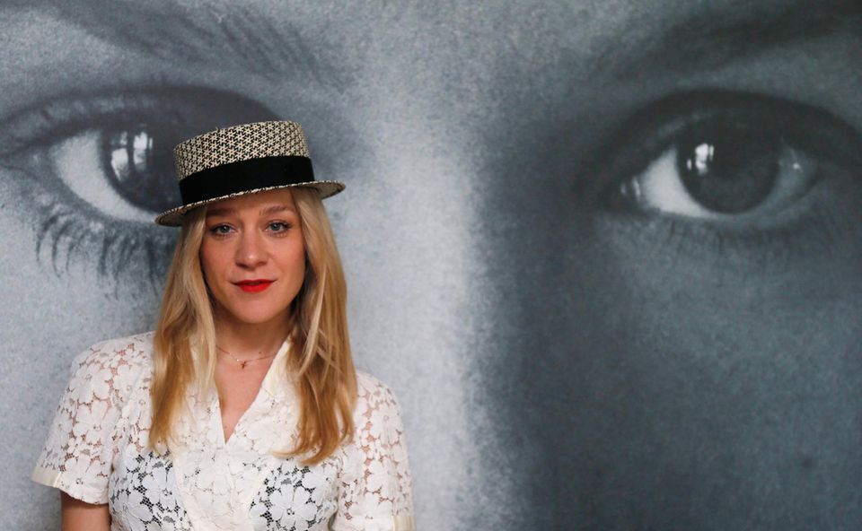 Schlicht mit Hut posiert Chloë Sevigny vor einem Schwarzweiß-Plakat. Sie ist zu einer Veranstaltung von "Kering Women in Motion" eingeladen. Schlicht mit Hut posiert Chloë Sevigny vor einem Schwarzweiß-Plakat. Sie ist zu einer Veranstaltung von "Kering Women in Motion" eingeladen.