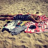 In eine USA-Flagge gehüllt, macht es sich Heidi Klum am Strand gemütlich.