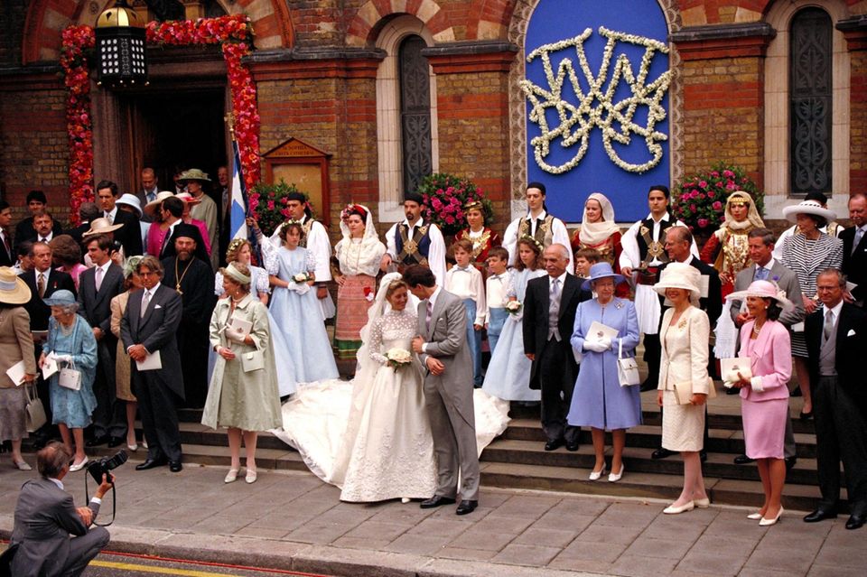 Aus Marie-Chantal Miller wird am 17. Juli 1995 eine Prinzessin von Griechenland und Dänemark. Zur Hochzeit mit Prinz Pavlos in London reist die gesamte royale Verwandtschaft des Bräutigams an und der Fotograf hat Mühe, die Könige und Königinnen in einem Foto zu verewigen. Unter den Gästen sind unter anderem (ganz links) König Juan Carlos von Spanien, Dänemarks ehemalige Königin Ingrid (Großmutter des Bräutigams; links 1. Reihe), König Hussein von Jordanien (rechts neben dem Brautpaar), Queen Elizabeth (rechts von Hussein), Königin Silvia und König Carl Gustaf von Schweden (ganz rechts), Großherzog Jean und Großherzogin Joséphine Charlotte von Luxemburg (rechts, 3. Reihe), Prinz Charles und Prinz Philip (rechts, 2. Reihe).