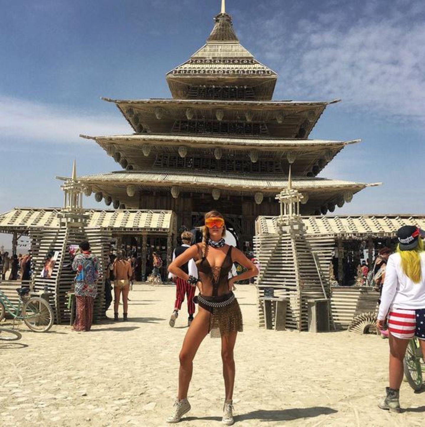 Im Schnür-Monokini posiert Model Nina Agdal vor dem "Burning Man Tempel" und sieht damit etwas aus wie eine Kriegerin aus der Zukunft. Die großen verspiegelten Sonnenbrillen, die an die Ski-Piste erinnern, sind übrings das Must-Have des Festivals.