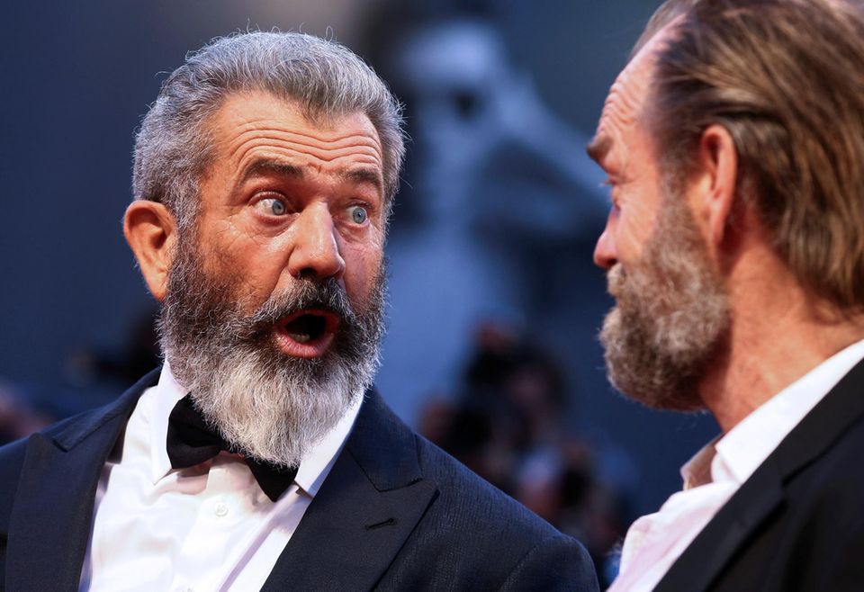 Mel Gibson belustigt seinen Schauspielkollegen Hugo Weaving auf dem roten Teppich mit lustigen Grimassen.
