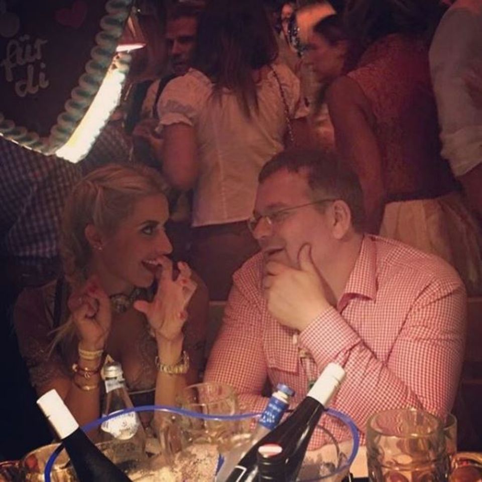 Verena Kerth versucht Elton die typischen "Wiesn-Griffe" zu erklären. Er scheint sehr vertieft zuzuhören.