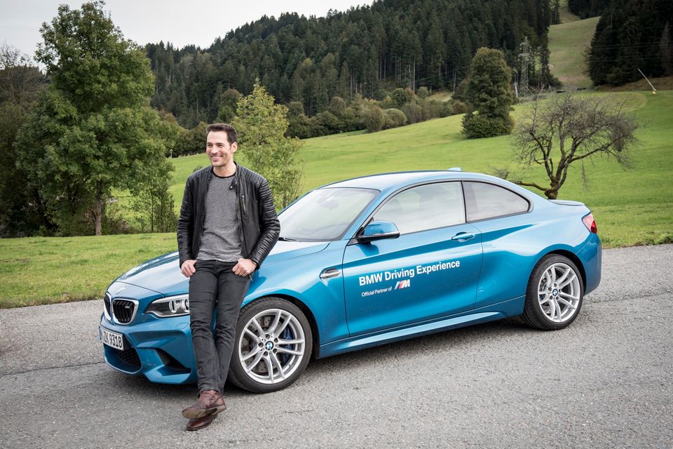 Moderator Alexander Mazza posiert vor einem BMW M.