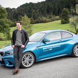 Moderator Alexander Mazza posiert vor einem BMW M.