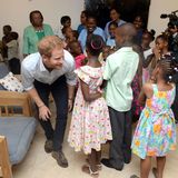 Noch sind die Kinderheimbewohner etwas schüchtern: Auf süße Art und Weise gibt sich Prinz Harry alle Mühe das Eis zu brechen.