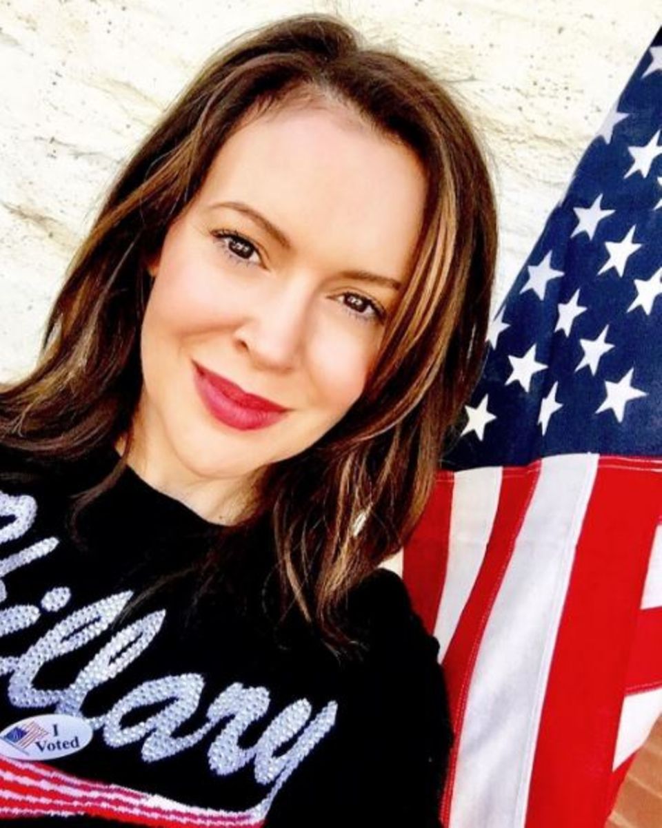 Alyssa Milano trägt einen Pulli mit Glitzer-Hillary-Schriftzug.