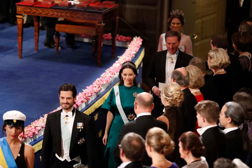 Prinzessin Sofia, Prinz Carl Philip, Chris O'Neill und Prinzessin Madeleine kommen zu ihren Plätzen im Konzerthaus.