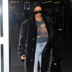 Es ist das erste von drei Pelz-Outfits, die Kim Kardashian an diesem Tag trägt: Bei ihrer Ankunft am New Yorker Flughafen trägt sie zu ihrem schwarzen Fellmantel ein Sinead O'connor Shirt und zerrissene Jeans.