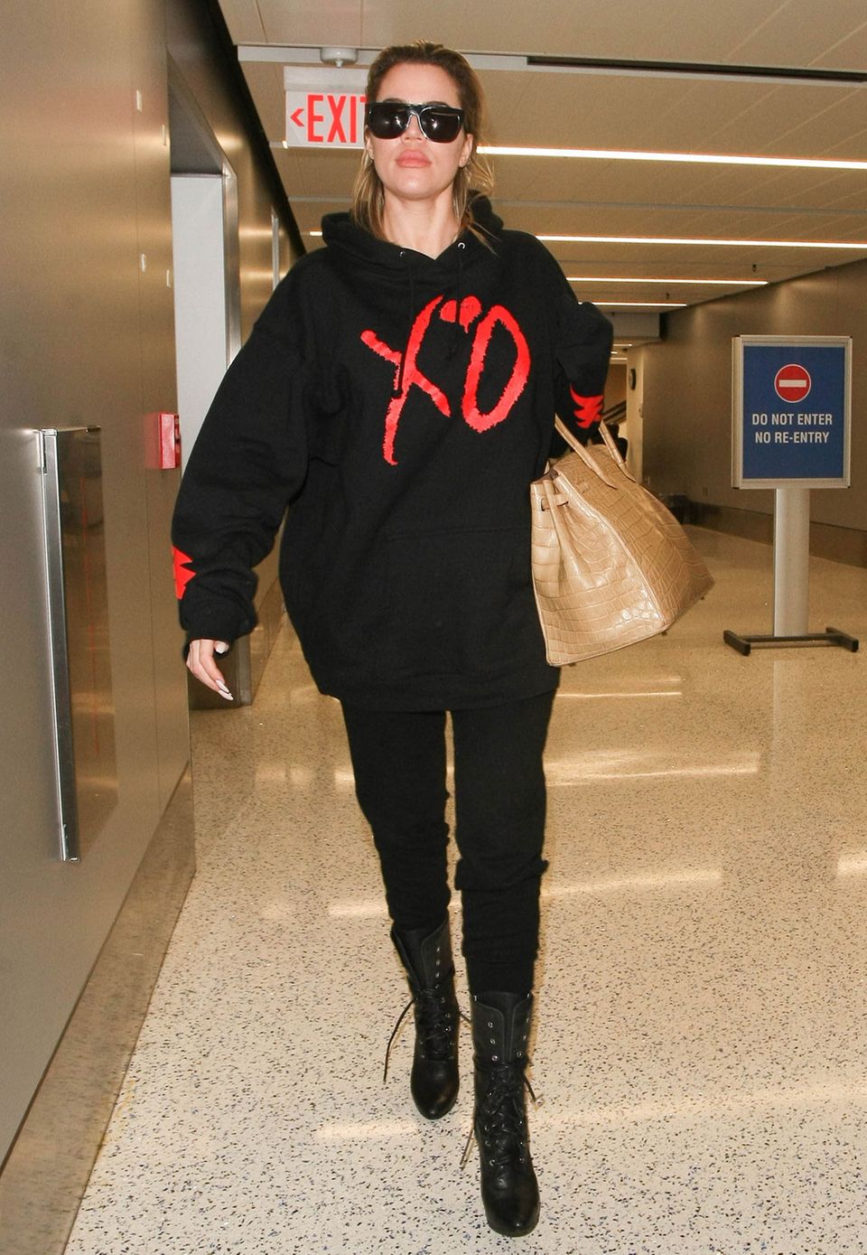 Nanu, was für eine verrückte Zusammenstellung. Khloe Kardashian reist zwar im lässigen Gemütlich-Look mit Sweater und schmaler Hose, akzentuiert diesen jedoch mit einer sündhaft teuren "Birkin Bag" aus Krokoleder, die schnell mal 40.000 Euro kosten kann.