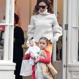 Stylisches Mutter-Tochter-Duo: Victoria Beckham und ihre Tochter Harper spazieren durch London. Victoria trägt zur gelben Schlaghose einen hellen Strickpulli. Harper ist in einem roten Kleidchen und grauer Wollstrumpfhose unterwegs.