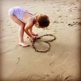 Dezember 2016   Theodora malt ein Herz in den Sandstrand und rührt damit ihre Mama. Ayda betitelt es mit Mamas Liebling.
