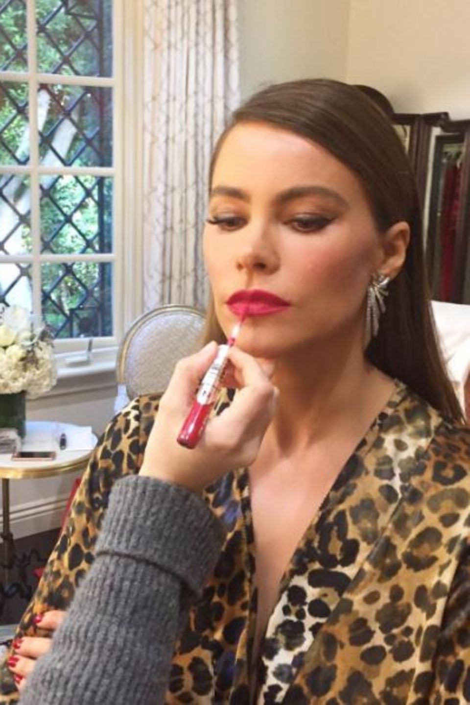 Der letzte Schliff: Stylistin Kayleen McAdams zieht Sofía Vergaras Lippen vorsichtig mit einem pinkroten Gloss nach.