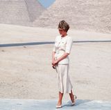 In einem sand-farbenen Ensemble mit Taillengürtel und großen goldenen Knöpfen posiert Prinzessin Diana vor den Pyramiden in Ägypten im Jahr 1992. 