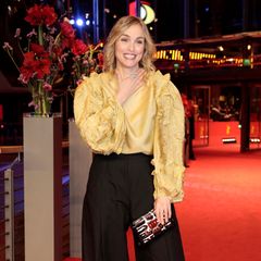 Nina Hoss zeigt sich mit extravaganter Seidenbluse und Marlene-Hose auf dem roten Premierenteppich von "Return to Montauk" modisch wagemutig.