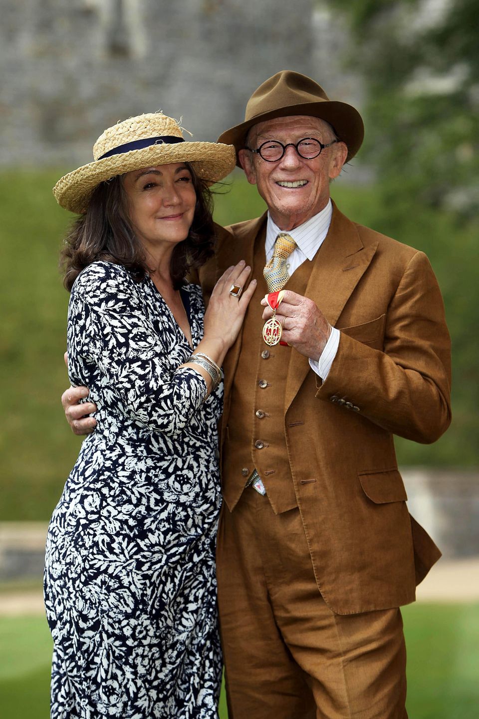 17. Mai 2015  "Harry Potter"-Mime John Hurt freut sich mit seiner Frau Anwen gemeinsam über das Schmuckstück, das ihn gerade bei der Investitur von Queen Elizabeth umgehängt wurde: Er ist jetzt Ritter.