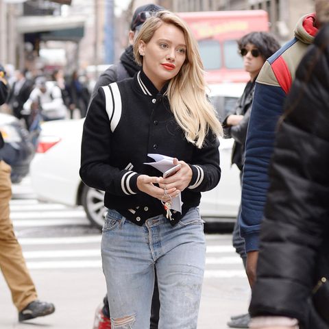 Hilary Duff mixt gleich drei Trends in einem Outfit: Collage-Jacke, zerrissene Mom-Jeans und weiße Stiefeletten. 