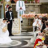 Bei ihrer Hochzeit erweisen Prinz Carl Philip und Prinzessin Sofia, seine gerade angetraute Frau, dem königlichen Schwiegervater Carl Gustaf die Ehre. Dieser nickt zu der Geste.