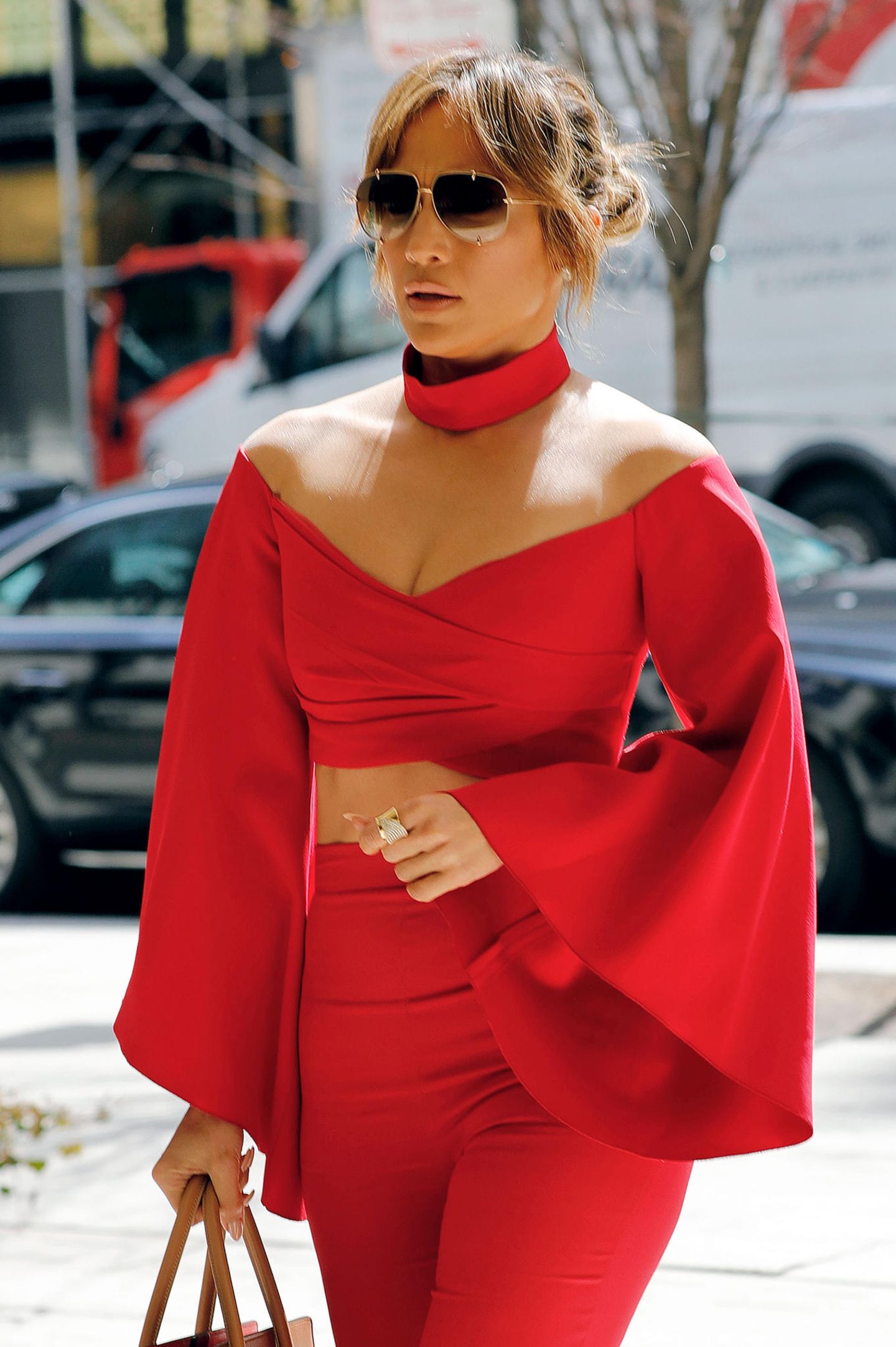 Wie ein Bauchfrei-Look besonders edel wirkt, zeigt uns Jennifer Lopez. Sie wählt ein kurzes Oberteil, das durch elegante Trompetenärmel besticht und kombiniert es zu Choker und High-Waist-Hose im selben Ton. So verwandelt sie sich zur "Lady in Red".