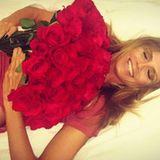 Für mich soll's rote Rosen regnen: Heidi Klum lässt sich freudestrahlend mit einem riesigen Blumenstrauß ins Bett fallen.  
