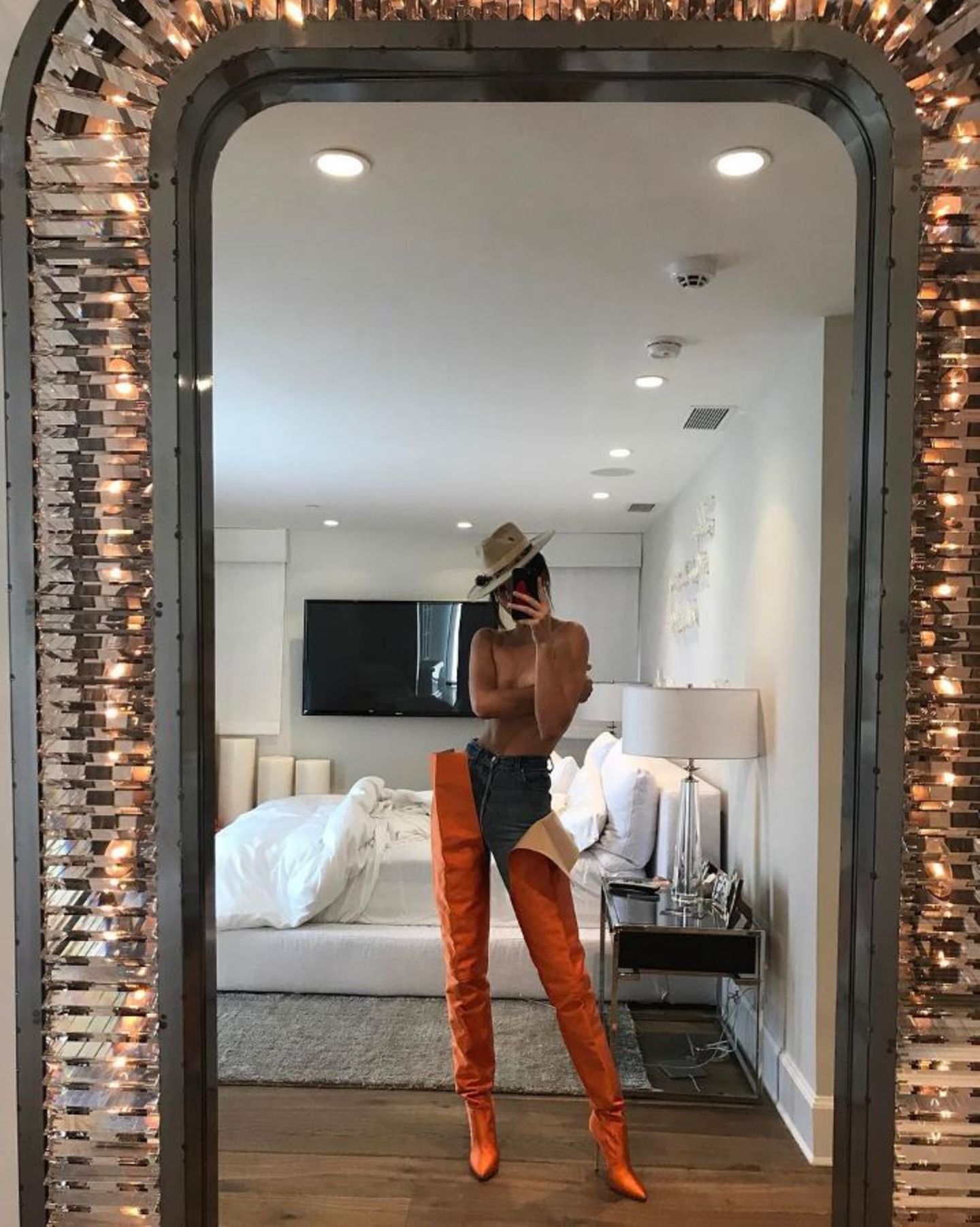 Kendall Jenner posiert nur in diesen orange-farbenen Hingucker-Stiefeln aus der Kollektion von Manolo Blahnik und Vetements und einer Jeans vor einem riesigen Spiegel. Ob das Geld nach den Boots (ein Paar kostet 3.590 Euro) nicht mehr für ein Oberteil gereicht hat? 