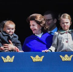 König Carl Gustaf feiert seinen 71. Geburtstag 2017 mit der ganzen Familie. Prinz Oscar kann das Geschehen im Schlosshof mitverfolgen verfolgen: Mama Victoria hat ihren Sohn auf dem Arm, Oma Silvia erklärt.