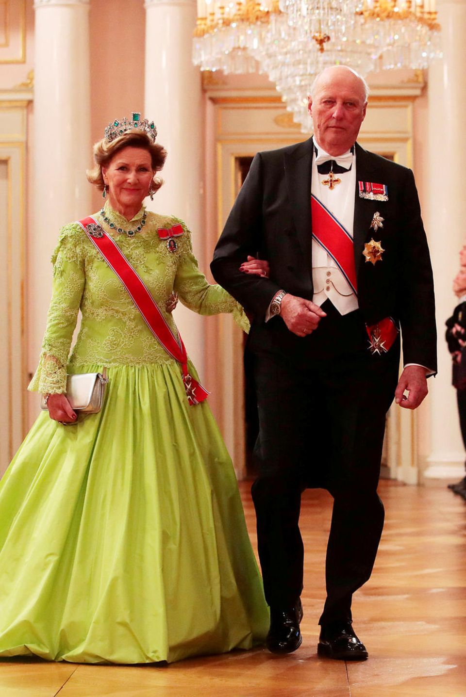 Vorbei am Spalier der Palast-Garde schreitet das norwegische Königspaar Sonja und Harald zum festlichen Gala-Dinner anlässlich der Feierlichkeiten zu ihrem 80. Geburtstag. Königin Sonja überrascht im neonfarbenen Ballkleid, das sie mit dem prächtigen Smaragd-Geschmeide der Kaiserin Josephine kombinierte.