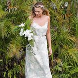 Diesen setzt Margot Robbie auch perfekt um: Sie wählt ein einfaches Midi-Kleid mit blassem Blumenprint und hübschem Spitzensaum. Bei den Accessoires hält sie sich ebenfalls zurück. Ihre Riemchen-Sandaletten fallen kaum auf und auf Schmuck verzichtet sie komplett. Dafür hält sie jedoch einen hübschen Orchideen-Strauß und hat sich Hibiskusblüten ins Haar geflochten. Besonders schön daran: Mit diesen Blickfängen greift sie den Standort der Location - nämlich Hawaii - auf. 