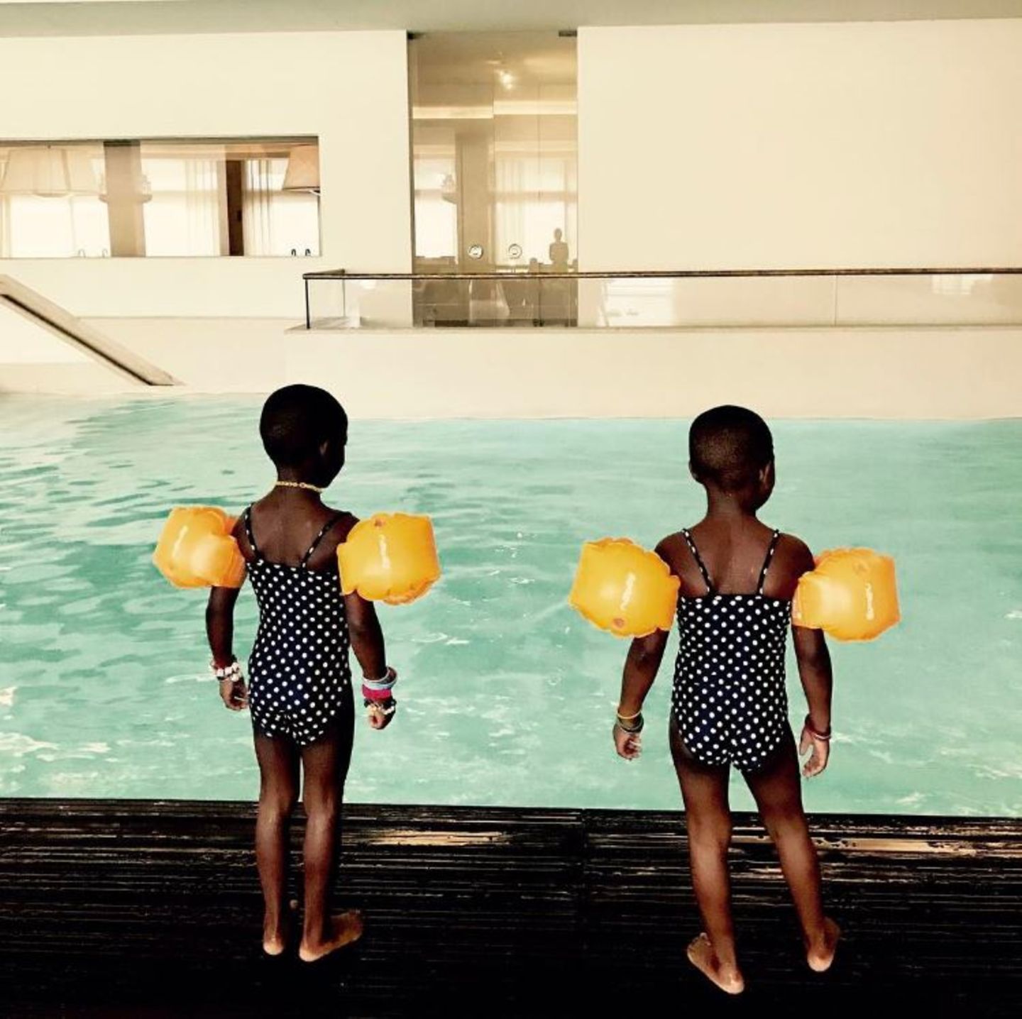 15. Mai 2017   Madonnas Zwillinge sind eine Augenweide. In ihren Pünktchen-Badeanzügen und gelben Schwimmflügeln bringen Stella und Esther etwas Farbe in den grauen Alltag. Die Woche beginnt mit Schwimmunterricht. 