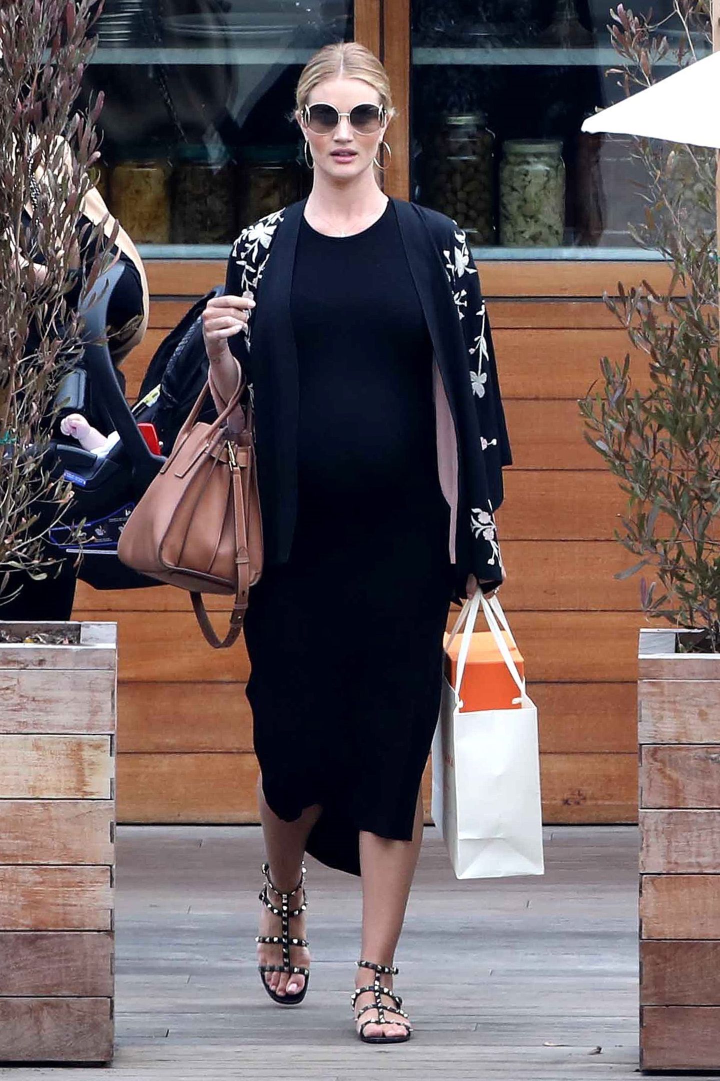 Von vorne ist dem Model die Schwangerschaft fast nicht anzusehen. Zum Lunch mit Freunden im "Soho House" trägt sie ein schwarzes Maxi-Dress, coole Nietensandalen von Valentino und ein schwarzes Jäckchen. 