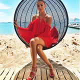 Lasziv posiert Steffi in diesem Hängesessel am Strand in Südfrankreich. So kommt das knallige Rot ihres roten Off-Shoulder-Kleides vom australischen Label "AliceMcCall" perfekt zur Geltung. 