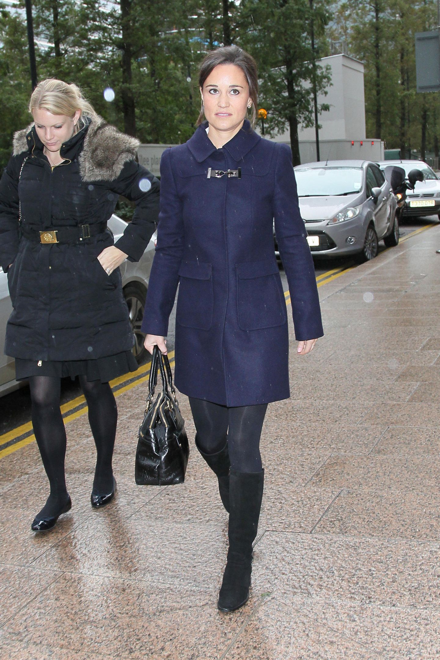 Gedeckte Farben: Pippa trägt einen marineblauen Mantel, dazu schwarze Stiefel. 