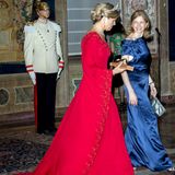 In einer roten Robe mit Schleppe und weiten Ärmeln begleitet Königin Máxima Laura Mattarella, die Frau des italienischen Präsidenten, zum Staatsbankett im Quirinalspalast. 
