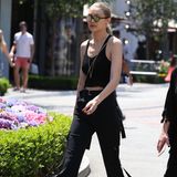In diesem Outfit beweist Gigi Hadid, dass Schwarz auf keinen Fall nur eine Farbe für den Winter ist. Zur coolen Schlaghose mit Schlaufen kombiniert sie ein schlichtes Tanktop und Schmuck. 