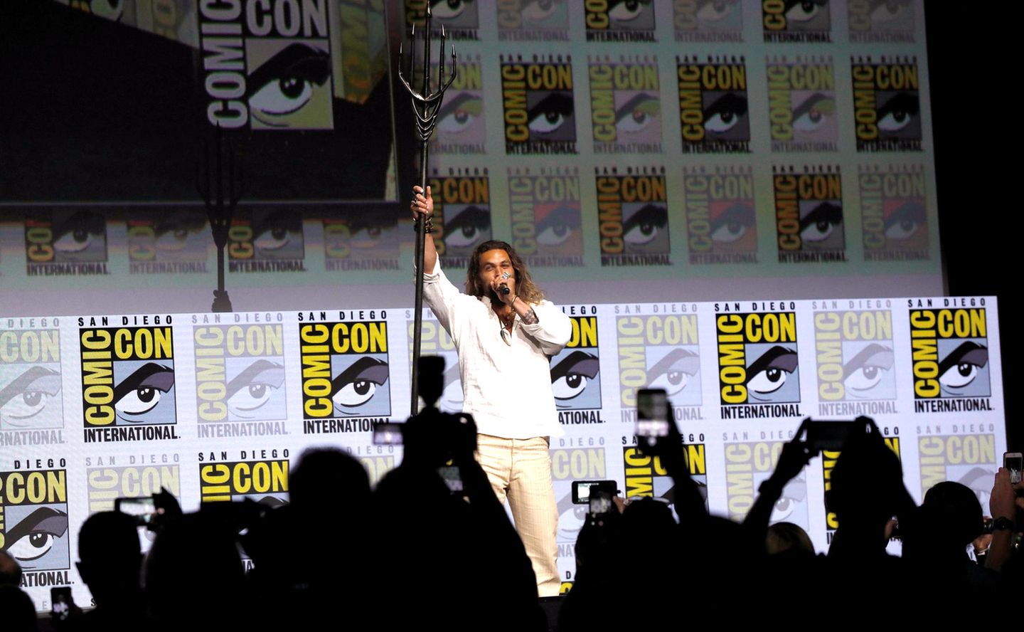 "Aquaman" Jason Momoa schwingt auf der Bühne seinen Dreizack. 