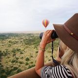 Einen auch so schon sagenhaften Ausblick schmücken bunte Heißluftballons über Kenias Savanne. Dank des Fernglases hat Schauspielerin Julianne Hough alles im Blick.