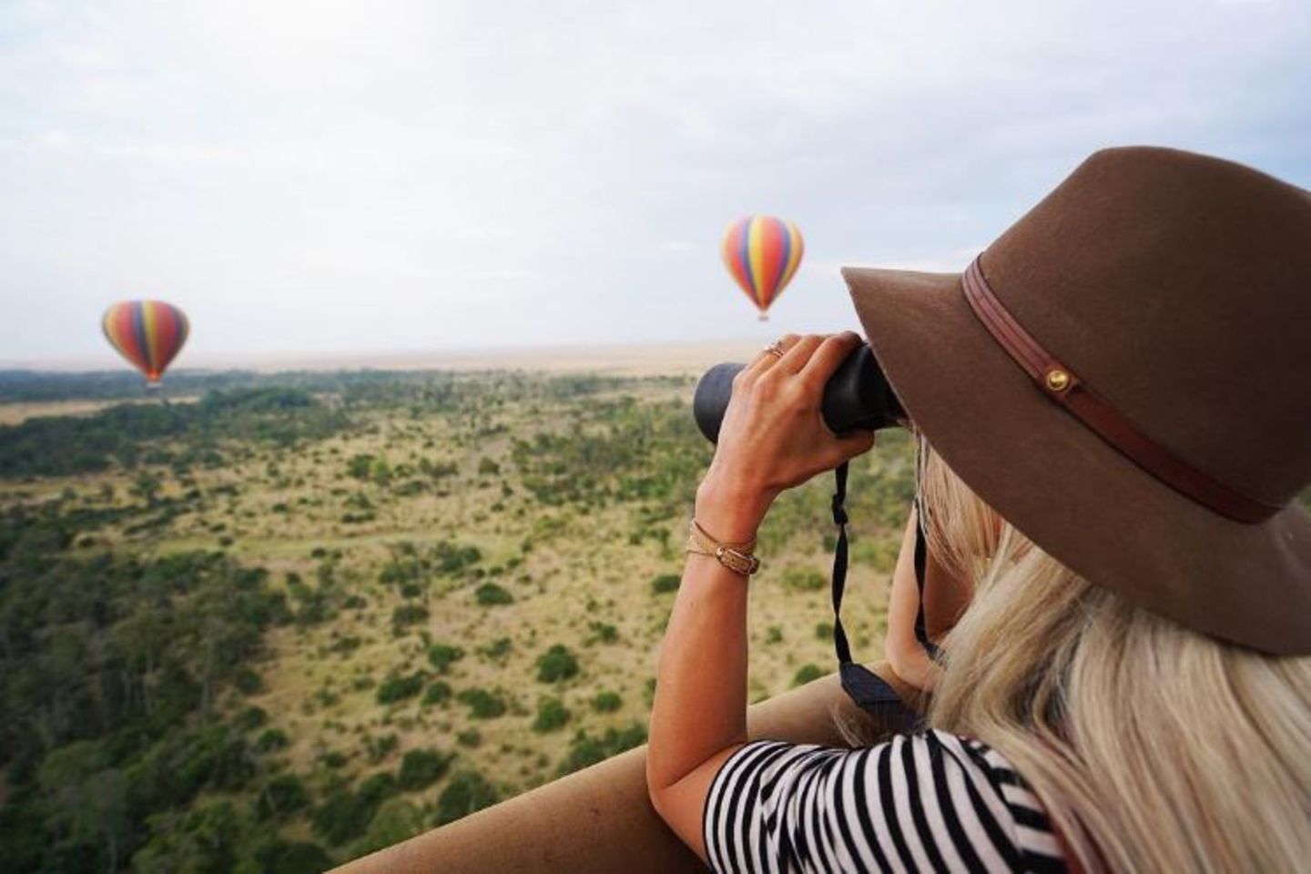 Einen auch so schon sagenhaften Ausblick schmücken bunte Heißluftballons über Kenias Savanne. Dank des Fernglases hat Schauspielerin Julianne Hough alles im Blick.