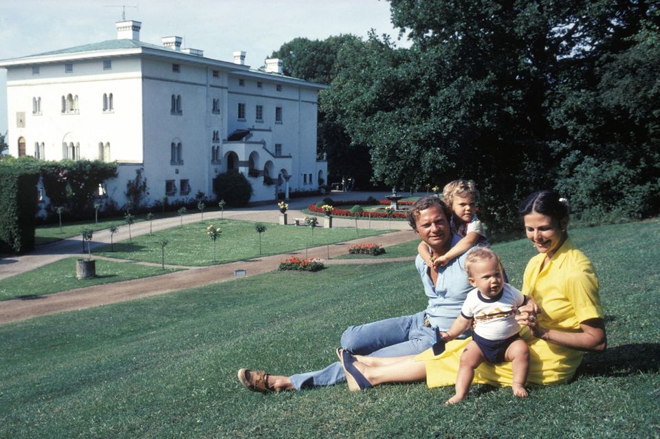 Sommerglück fühlt sich hier zeitlos an: König Carl Gustaf und Königin Silvia im Jahr 1980 mit Victoria (bei Papa) und Carl Philip vor Schloss Solliden