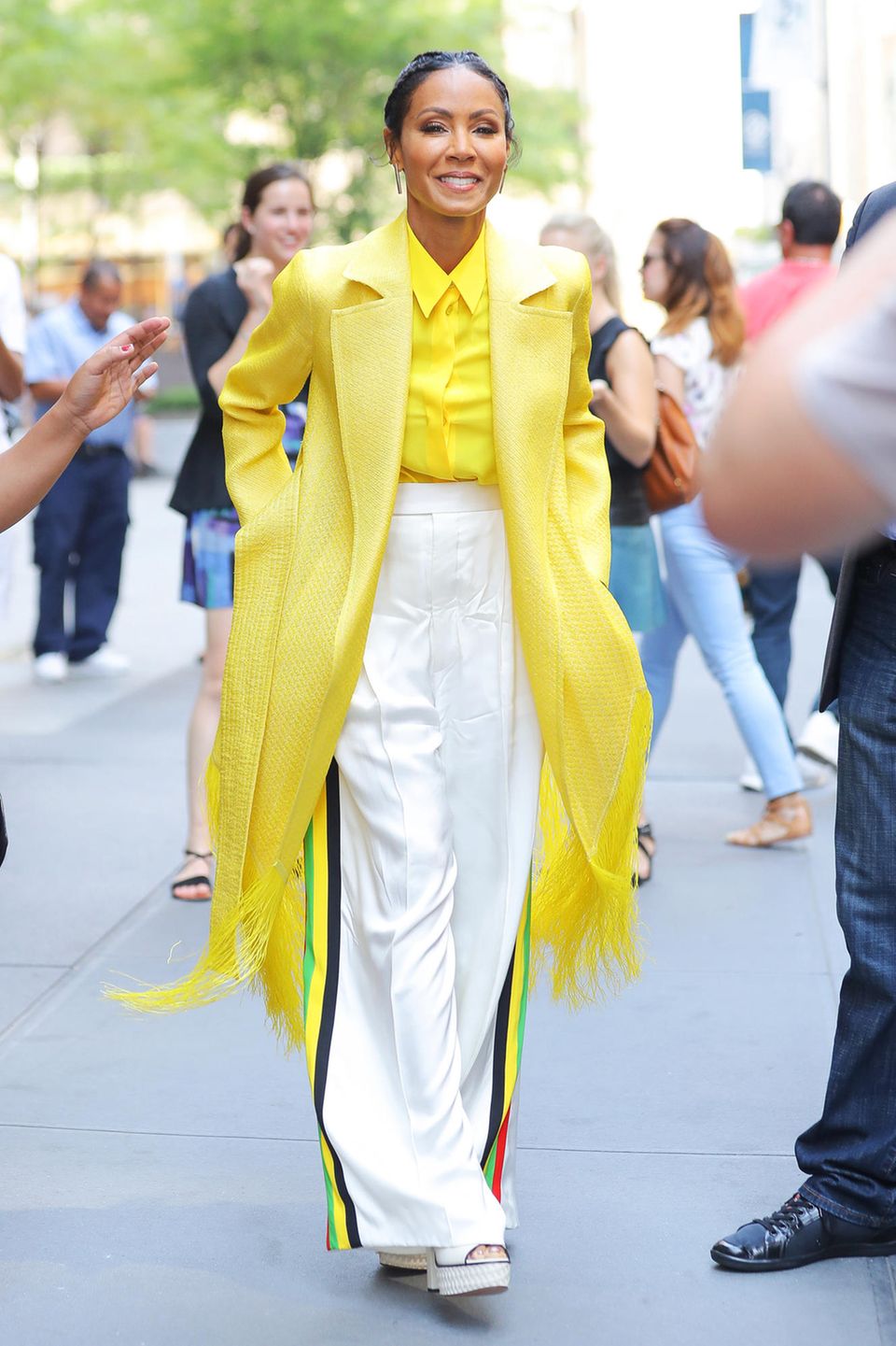 Modisch geht bei Jada Pinkett Smith die Sonne auf. Zur weißen Hose mixt sie Mantel und Bluse in Gelb-Tönen
