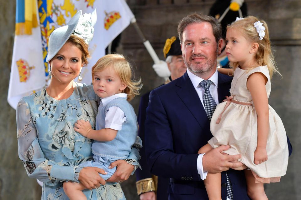 14. Juli 2017  In Schweden feiert die Königsfamilie den Geburtstag von Prinzessin Victoria. Prinzessin Madeleine und Ehemann Chris sind mit den Kindern angereist.  Nicolas schaut ganz artig vom Arm seiner Mutter im Eingang zur Schlosskirche. Leonore scheint wieder etwas im Sinn zu haben.