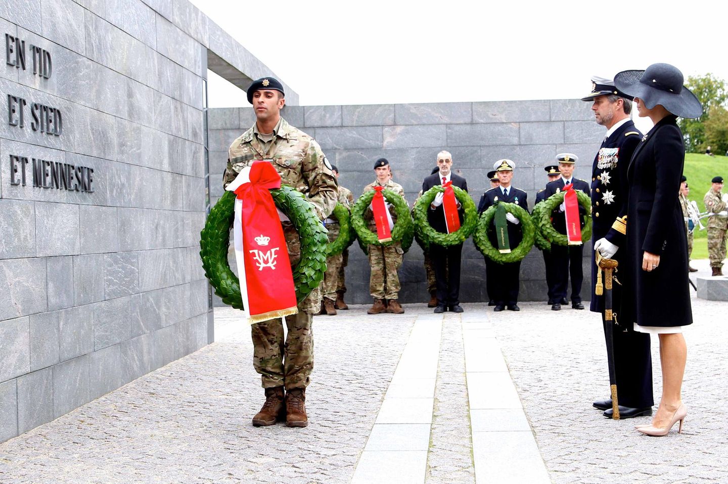 5. September 2017  Am sogenannten Flaggentag legen Prinzessin Mary und Prinz Frederik zum Andenken an dänische Soldaten, die im Ausland gefallen sind, einen Kranz nieder. Auf der roten Schleife prangt ihr gemeinsames Monogramm.