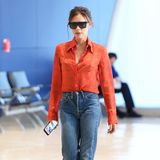 Ungewohnt lässig flaniert Designerin Victoria Beckham in einer "Mom-Jeans" über den "JFK Airport" in New York. Dazu kombiniert sie eine orangefarbene Bluse, eine "Posh"-Sonnenbrille und glitzernde "Harper"-Pumps (benannt nach ihrer Tochter) aus ihrer eigenen Kollektion. 