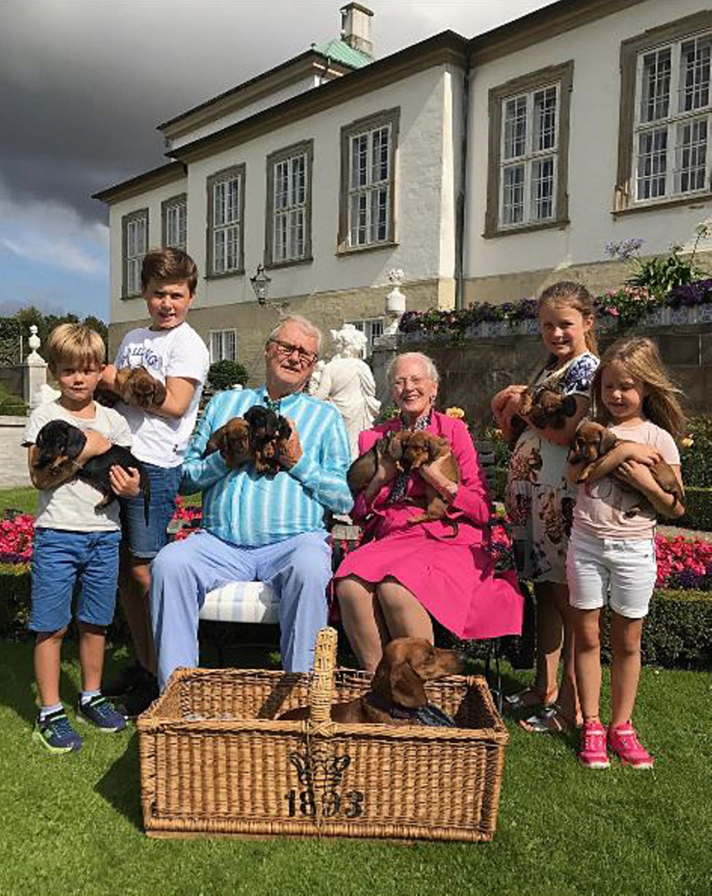 Die Liebe zum Hund ist im dänischen Königshaus generationsübergreifend. Als Prinz Henriks Hündin (vorne im Korb) Welpen bekommt, dürfen die vier Enkel mit Welpen in die Kamera halten. Schließlich sollen sich alle mit über den vierbeinigen Nachwuchs freuen können.