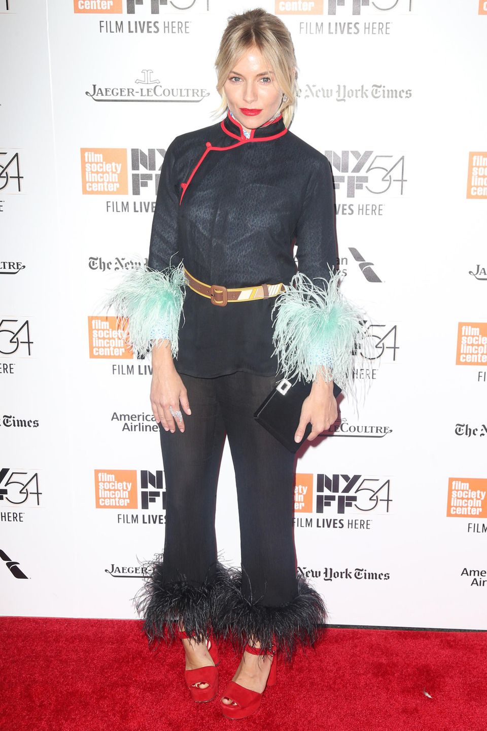 Bei Sienna Millers Red-Carpet-Auftritt in New York treffen Asia-Look und fedrige Details aufeinander.