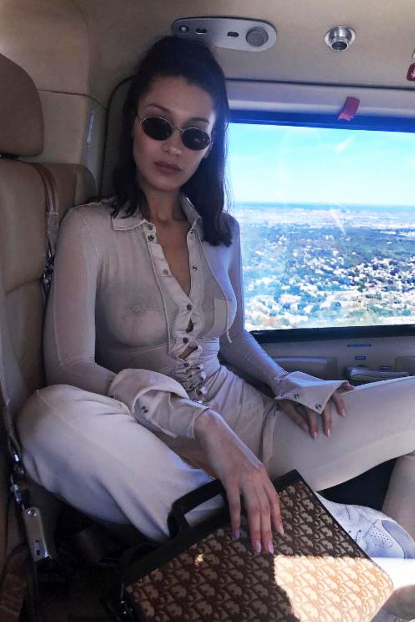 Ob Model Bella Hadid ihr Outfit auf die Inneneinrichtung des Fliegers abgestimmt hat? Nichtsdestotrotz schaut man vor allem auf ein nicht vorhandenes Detail: Bella verzichtet getrost auf ihren BH und zeigt das auch gerne allen 