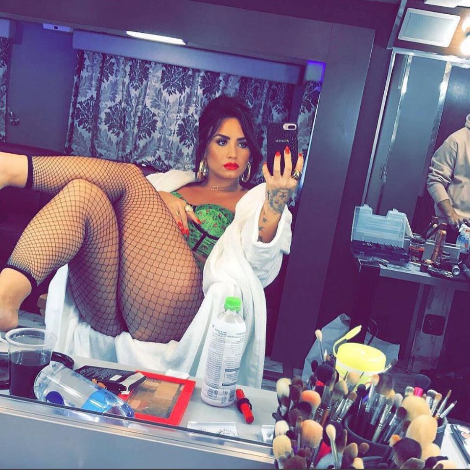Uhh là là! Sängerin Demi Lovato ist zwar nicht ganz nackt, gewährt aber trotzdem tiefe Einblicke. Sie posiert nur in Netzstrumpfhose und Korsage bekleidet vor dem Spiegel ihrer Maske. 