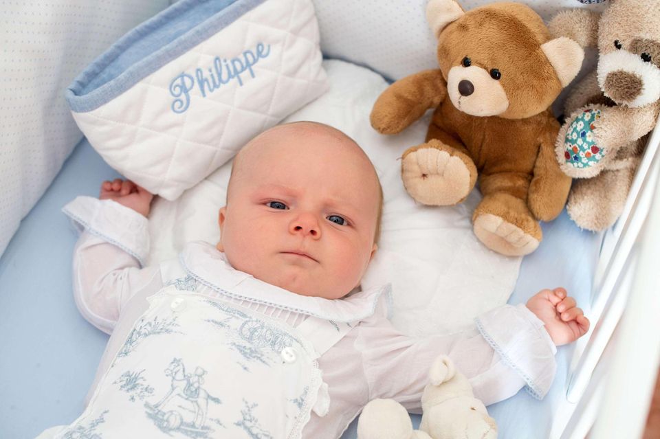 Der kleine Prinz in seinem Bett: Ganz wach und ernst schaut Philippe, der am 22. Oktober getauft wurde, bei seinem ersten Fototermin in die Kamera.