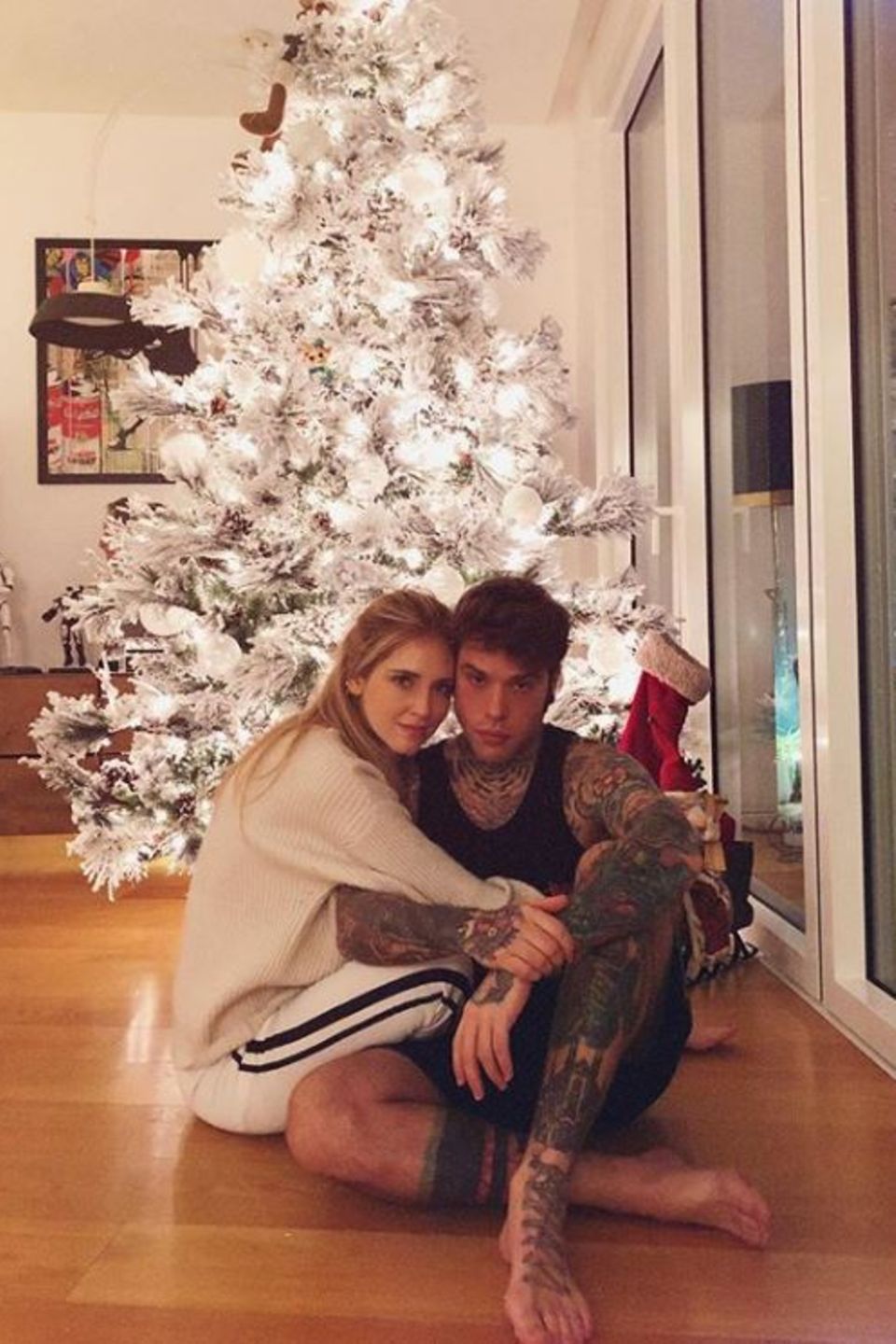 Chiara Ferragni und ihr Verlobter Fedez posieren vor ihrem wunderschön geschmückten Weihnachtsbaum.
