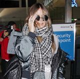 Dick verpackt und doch erkannt: Heidi Klum sieht sich im sportlichen, grauen Winter-Look und extragroßem Karo-Schal am Flughafen von L.A. doch wie üblich von vielen Paparazzi umgeben.